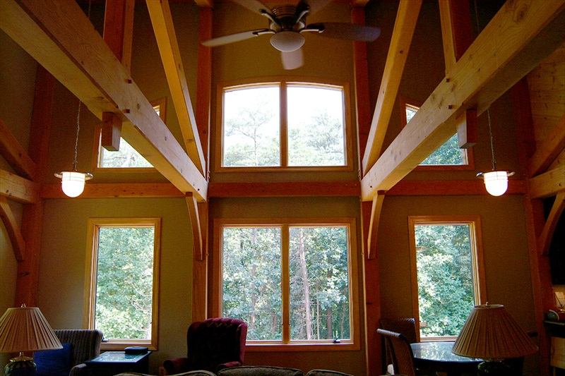 Private Residence open living room with windows overlooking forest.
